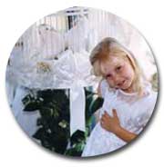 flower girl at wedding stands in front of doves in an ornate cage
